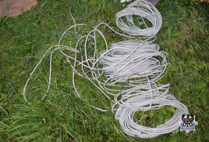 Na zdjęciu widać zwinięty kabel elektryczny, który leży na trawie