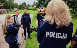 policjanci stoja i rozmawiają z chłopcem