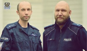 Dwaj umundurowani policjanci bez nakrycia głowy.