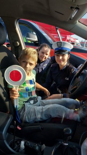 dzieci w środku radiowozu z policjantką