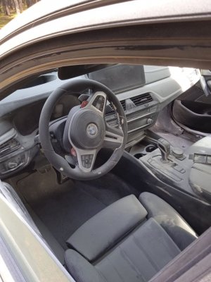 Na zdjęciu widać wnętrze pojazdu - kierownica, kokpit oraz fotel kierowcy.