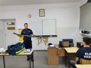 policjant naucza o pierwszej pomocy w klasie policyjnej