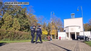 policjanci podążają alejką na cmentarzu