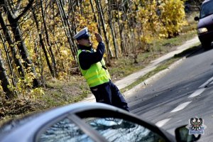 policjant ruchu drogowego stoi na drodze i kieruje ruchem