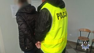 policjant prowadzi zatrzymanego