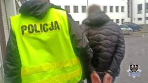 policjant prowadzi zatrzymanego