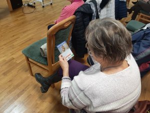 seniorka czyta ulotkę