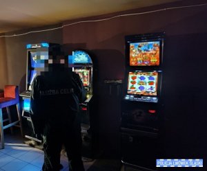 funkcjonariusz straży celnej stojący przy automatach do gier