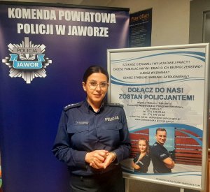 policjantka w mundurze stojąca na tle banera