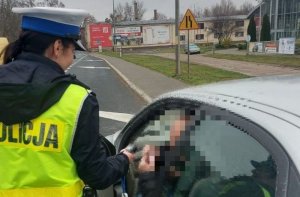 policjantka ruchu drogowego kontroluje trzeźwość kierowcy pojazdu