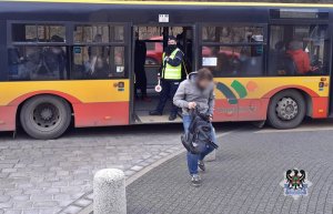 policjant w autobusie kontrolujący pasażerów