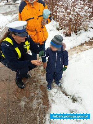 Policjantka wręcza dziecku odblask
