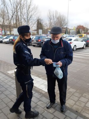 policjantka z ulotką rozmawia ze starszą osobą