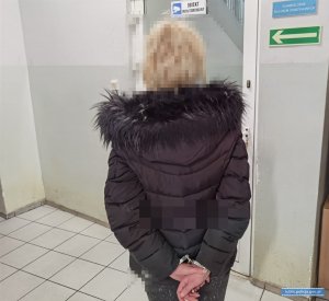 zatrzymana kobieta stojaca przed wejsciem do aresztu