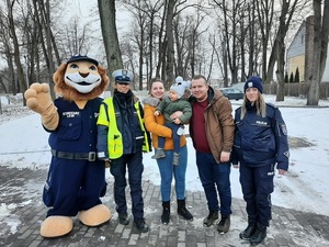 komisarz lew wspólnie z policjantami i rodziną małego chłopca stoją przy parku