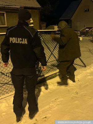 policjant stoi przy bramie obok mężczyzny