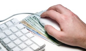 klawiatura komputera i myszka leżąca na pieniądzach