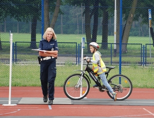 Policjantka  i dziecko jadące na rowerze
