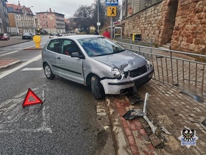 srebrny samochód rozbity na barierkach stojacy na drodze