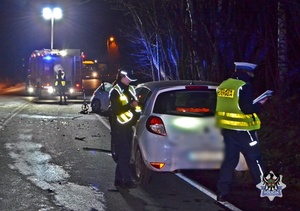 policjanci prowadzą czynności koło samochodu zniszczonego podczas wypadku