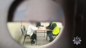 odzyskana biżuteria leżąca na teczce aktowej, pani przesłuchiwana siedzi przy biurku