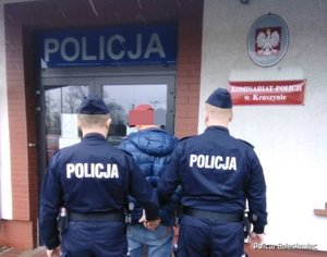 policjanci prowadzą zatrzymanego mężczyznę