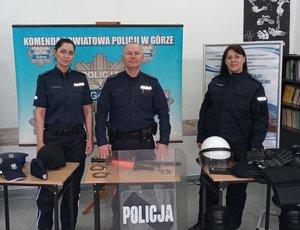 policjanci stojący przy stoliku z materiałami promocyjnymi