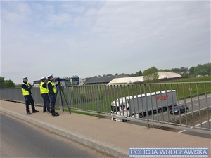 policjanci stojący na wiadukcie mierzący prędkość pojazdów
