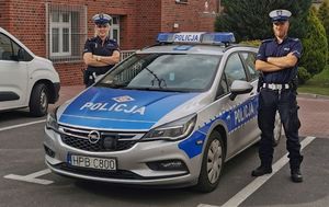 policjanci stoją obok radiowozu