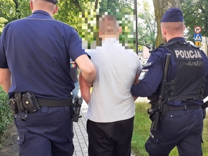 zatrzymany męzczyzna obok którego znajduje sie umundurowany policjant