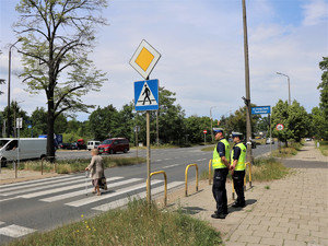 Policjanci wykorzystując ręczny miernik prędkości sprawdzają zachowania kierujących i pieszych w rejonie przejść dla pieszych