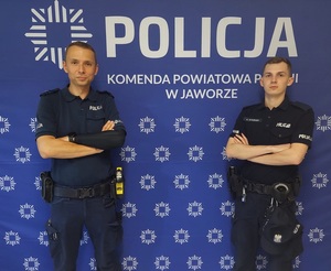 policjanci na tle napisu z komendy