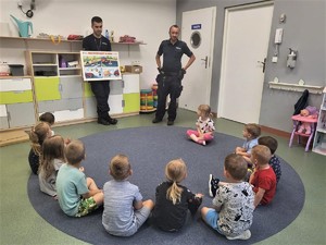 Zdjęcia przedstawiają policjantów oraz grupę dzieci, a także radiowóz.