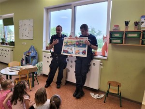 Zdjęcia przedstawiają policjantów oraz grupę dzieci, a także radiowóz.