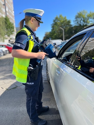 Policjantka stoi obok samochodu