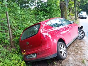 czerwone auto które rozbiło się na drzewie