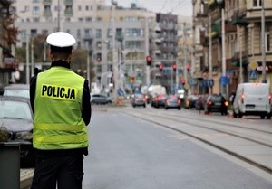 Zdjęcie przedstawia policjanta kontrolującego ruch na drodze