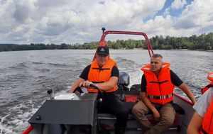 Dwóch funkcjonariuszy w kapokach płynie łodzią motorową