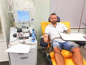 Zdjęcie przedstawia policjanta, który oddaje krew, a także odznakę koloru brązowego oraz niebieską legitymację
