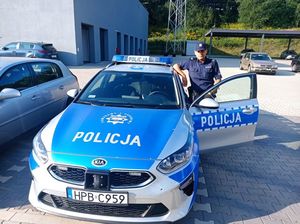 Policjant stoi przy radiowozie