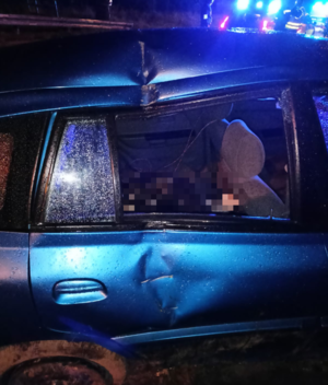 Na zdjęciu widać fragment (prawe tylne drzwi) niebieskiego samochodu uszkodzonego w wyniku zdarzenia drogowego