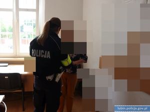 policjantka w mundurze stojąca obok osoby w pokoju z oknem