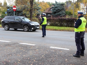 Umundurowany policjant za pomocą tarczy zatrzymuje pojazd