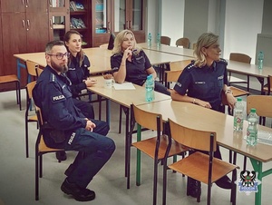 Czworo policjantów siedząca przy ławkach szkolnych