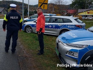 Na zdjęciu policyjne radiowozy i policjant