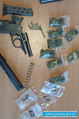Zdjęcie przedstawia foliowe opakowania z narkotykami oraz przedmiot przypominający broń