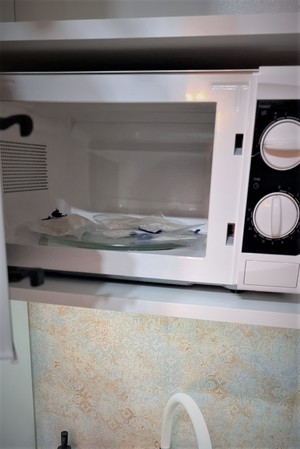 Zdjęcia przedstawiają ujawnione narkotyki schowane w mikrofalówce oraz kuchni i łazience