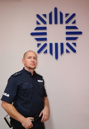 Policjant stoi przy ścianie