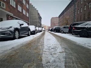 Pojazdy z warstwą śniegu na jednej z wrocławskich ulic