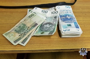 Plik banknotów leży na blacie stołu